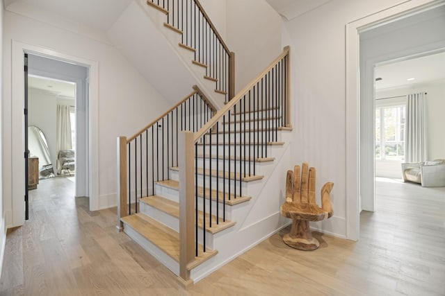 stairway featuring crown molding and wood-type flooring