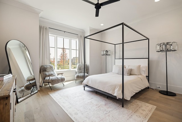 bedroom featuring ceiling fan, light hardwood / wood-style floors, and crown molding