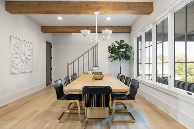 dining room with beamed ceiling, an inviting chandelier, and light hardwood / wood-style flooring