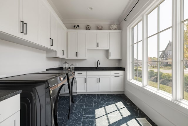 laundry room with cabinets, washing machine and clothes dryer, and sink