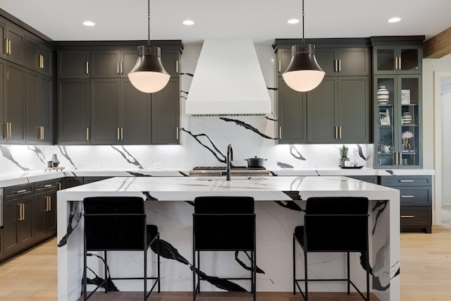 kitchen with premium range hood, hanging light fixtures, and a spacious island