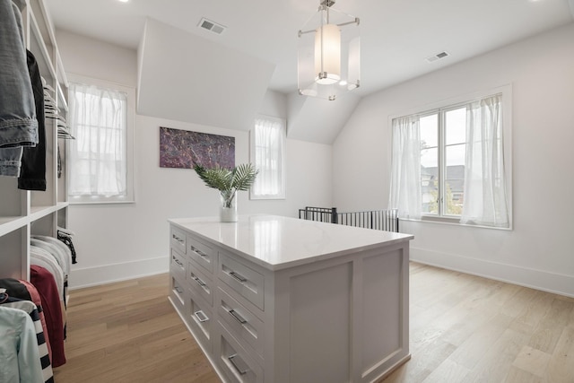 spacious closet with vaulted ceiling and light hardwood / wood-style flooring