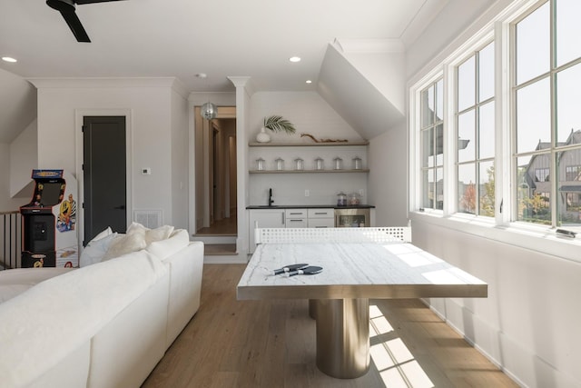 rec room featuring crown molding, sink, vaulted ceiling, and light wood-type flooring