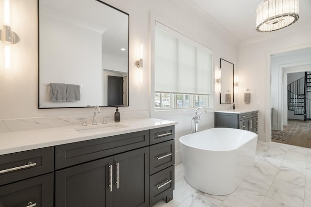 bathroom with a tub, crown molding, vanity, and a notable chandelier