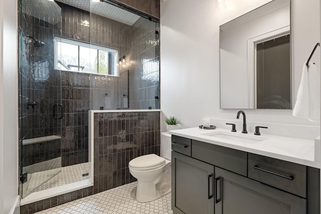 bathroom with tile patterned floors, vanity, an enclosed shower, and toilet