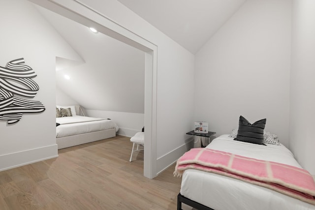 bedroom featuring vaulted ceiling and light wood-type flooring