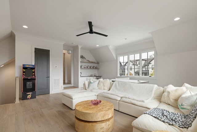 living room featuring vaulted ceiling, light hardwood / wood-style flooring, ceiling fan, and ornamental molding