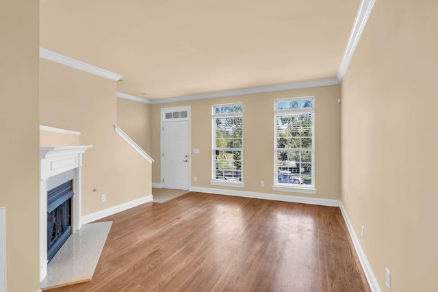 unfurnished living room with hardwood / wood-style floors, ornamental molding, and a fireplace