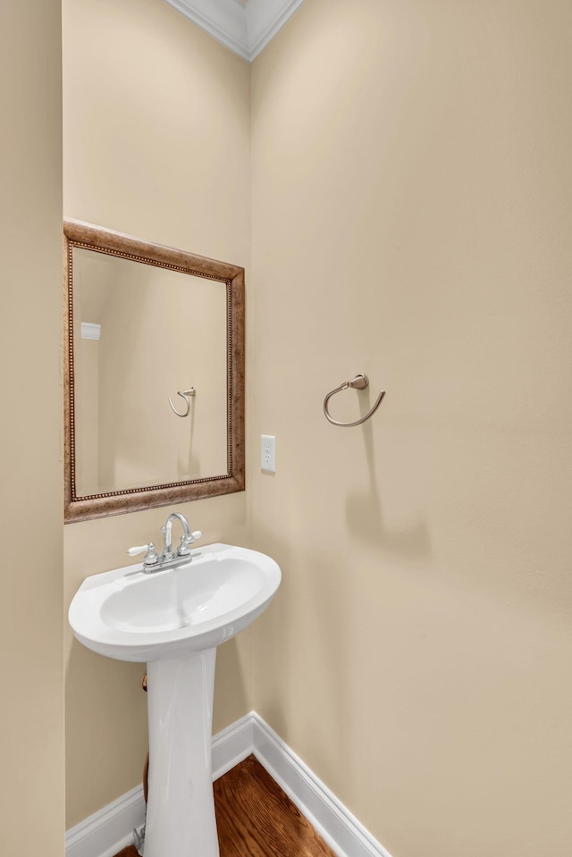 bathroom with hardwood / wood-style flooring and crown molding