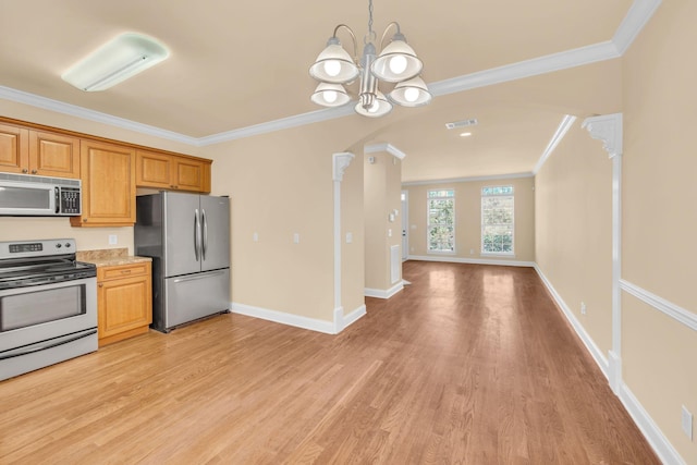 kitchen with appliances with stainless steel finishes, ornate columns, ornamental molding, light hardwood / wood-style flooring, and a notable chandelier