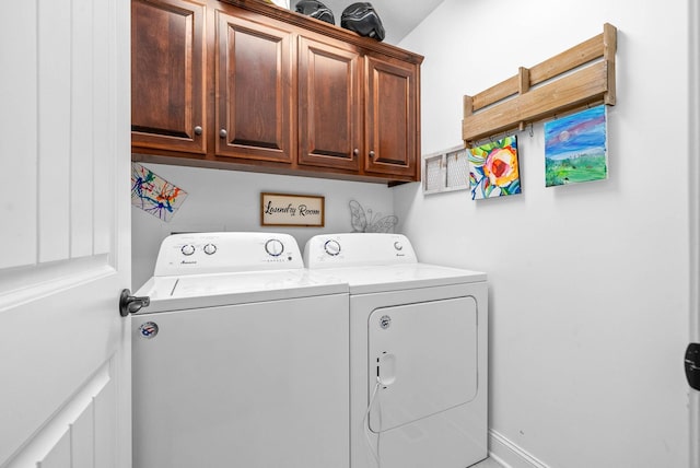 clothes washing area featuring cabinets and washer and clothes dryer