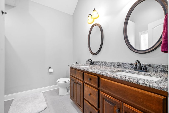 bathroom with toilet, vanity, tile patterned floors, and vaulted ceiling