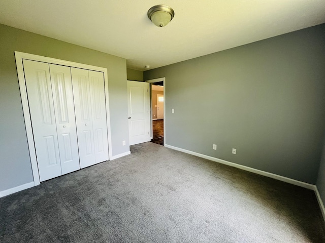 unfurnished bedroom featuring a closet and dark colored carpet