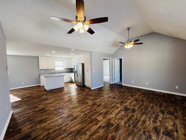 unfurnished living room with ceiling fan, dark hardwood / wood-style flooring, and vaulted ceiling