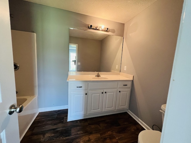 full bathroom featuring shower / bathtub combination, vanity, a textured ceiling, wood-type flooring, and toilet