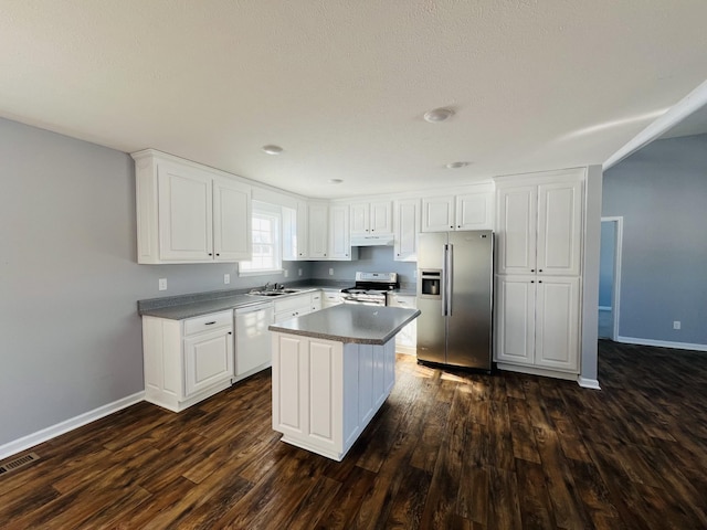 kitchen featuring a center island, dark wood-type flooring, sink, appliances with stainless steel finishes, and white cabinetry