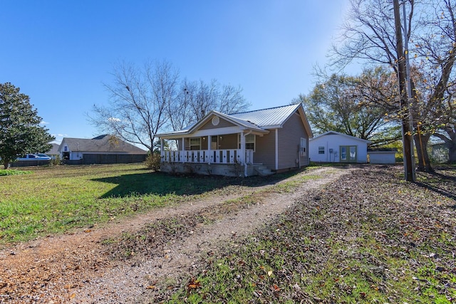 view of side of home with a porch and a yard