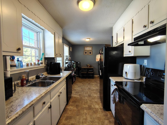 kitchen with black appliances, white cabinetry, sink, and a textured ceiling