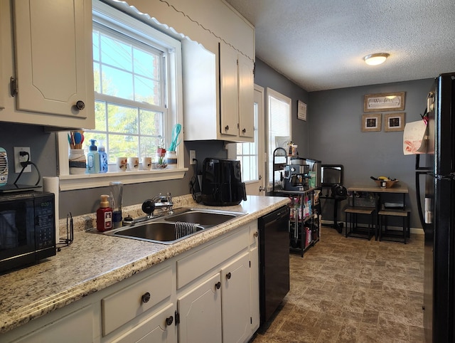 kitchen with white cabinetry, sink, black appliances, and a textured ceiling