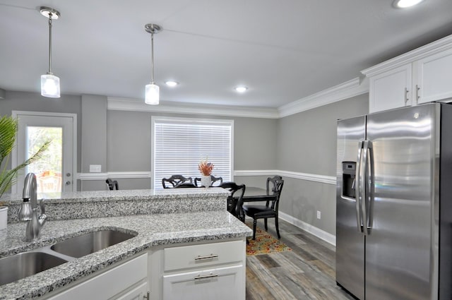 kitchen featuring decorative light fixtures, sink, white cabinets, stainless steel fridge, and crown molding