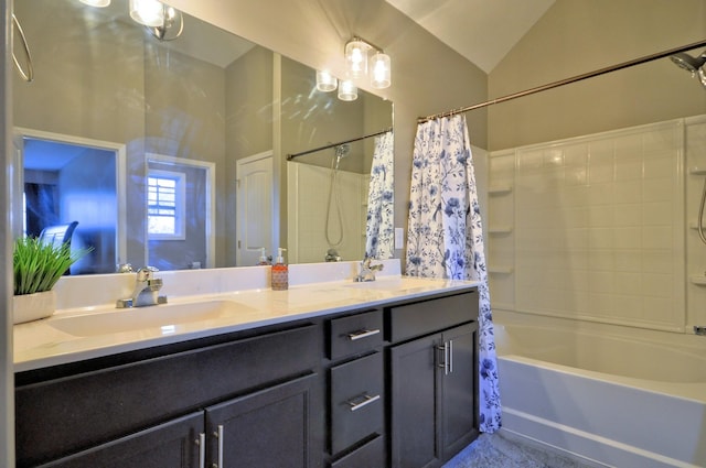 bathroom with lofted ceiling, shower / bath combo with shower curtain, and vanity