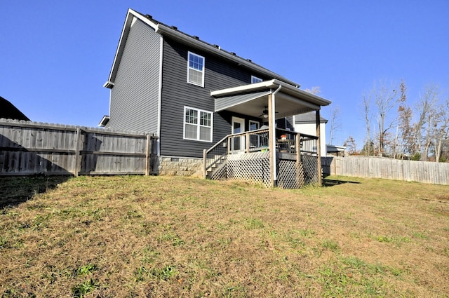 back of property featuring a wooden deck, ceiling fan, and a lawn