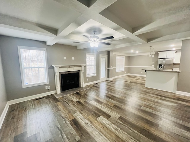 unfurnished living room with a premium fireplace, coffered ceiling, dark hardwood / wood-style floors, and beam ceiling