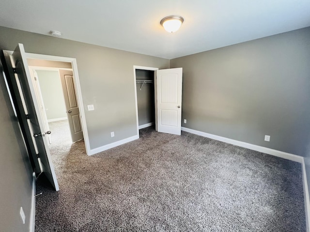 unfurnished bedroom featuring a closet and dark colored carpet