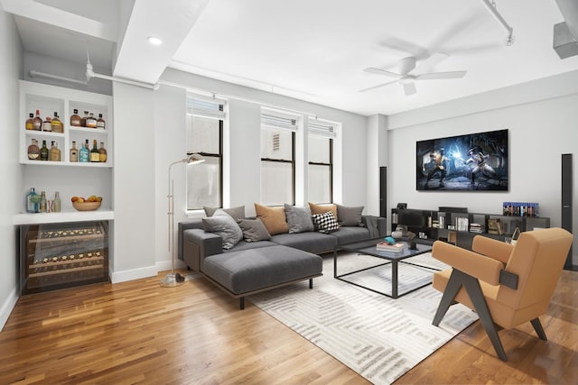 living room featuring ceiling fan, wood-type flooring, and bar