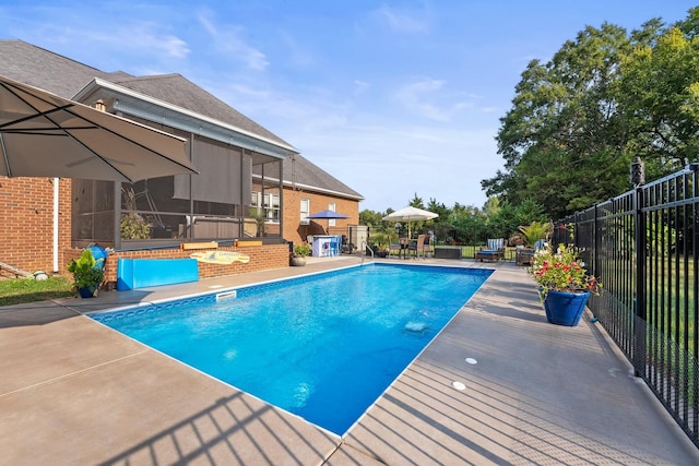 view of pool featuring a bar, a patio, and a sunroom