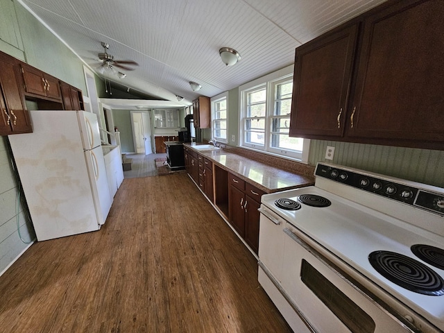 kitchen featuring white appliances, ceiling fan, dark wood-type flooring, sink, and lofted ceiling