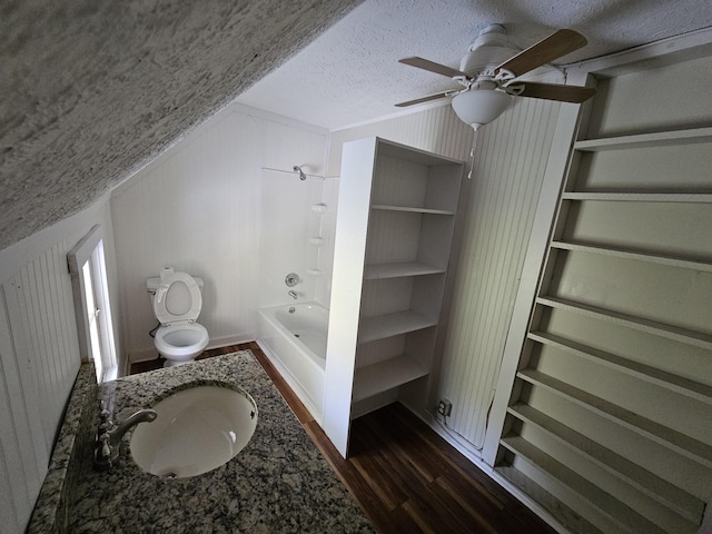 full bathroom with a textured ceiling, bathing tub / shower combination, ceiling fan, sink, and hardwood / wood-style floors