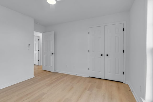 unfurnished bedroom featuring ceiling fan, a closet, and light hardwood / wood-style floors