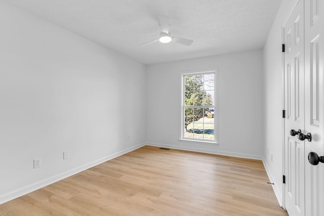 empty room with ceiling fan, a textured ceiling, and light hardwood / wood-style flooring