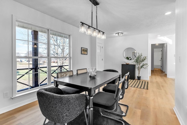 dining area with a textured ceiling and light wood-type flooring