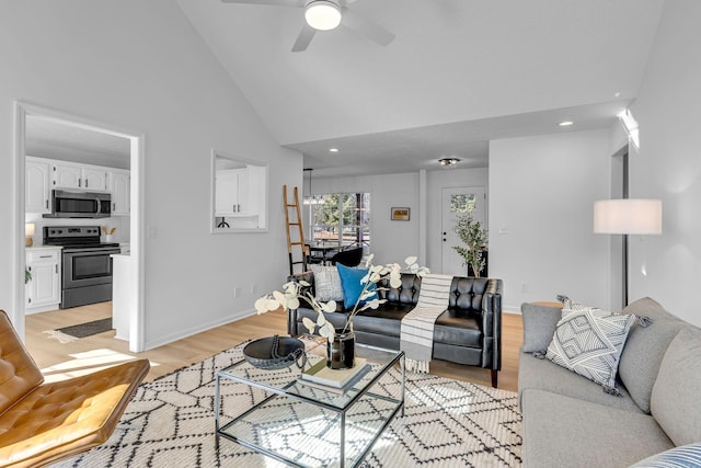 living room with ceiling fan, light wood-type flooring, and high vaulted ceiling