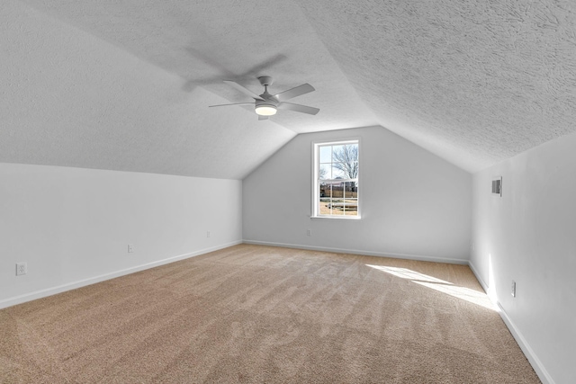 additional living space with ceiling fan, light carpet, a textured ceiling, and lofted ceiling