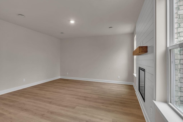 unfurnished living room featuring light hardwood / wood-style flooring and a fireplace