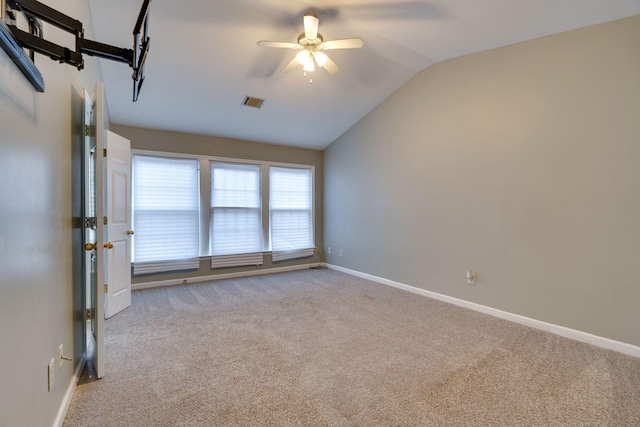 carpeted spare room with ceiling fan and lofted ceiling