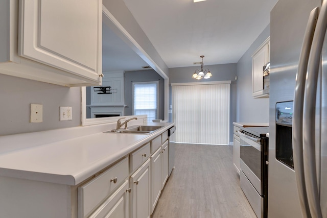 kitchen with white cabinets, decorative light fixtures, stainless steel appliances, and an inviting chandelier