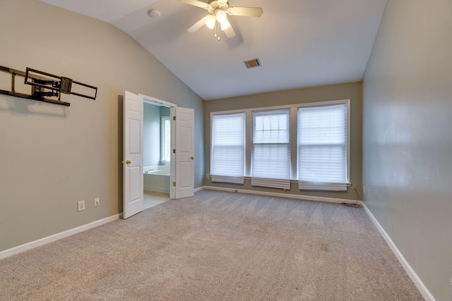 unfurnished bedroom with light carpet, connected bathroom, ceiling fan, and lofted ceiling