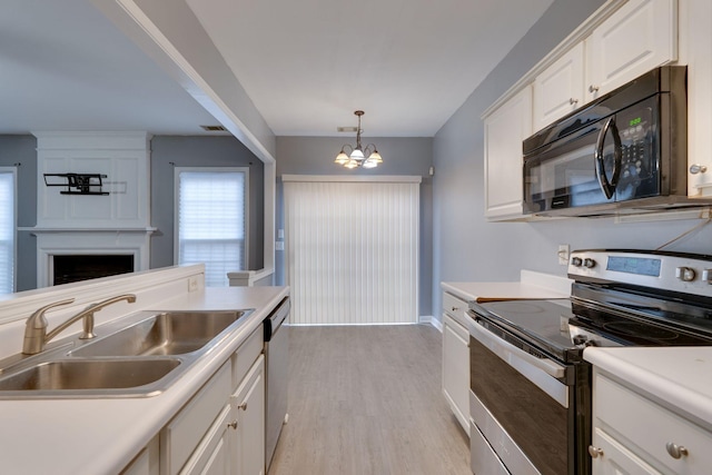 kitchen with sink, stainless steel appliances, a notable chandelier, pendant lighting, and white cabinets