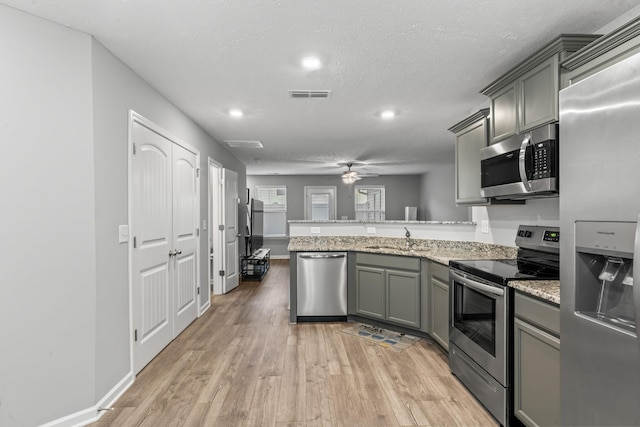 kitchen featuring sink, ceiling fan, gray cabinets, kitchen peninsula, and stainless steel appliances