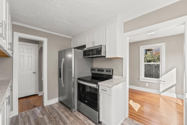 kitchen with white cabinets, light wood-type flooring, light stone counters, and stainless steel appliances