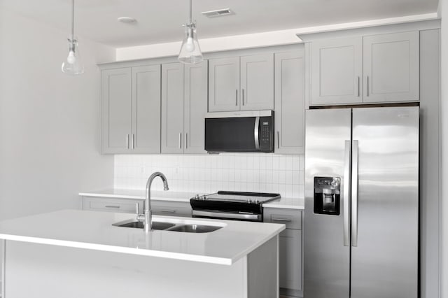 kitchen with appliances with stainless steel finishes, sink, backsplash, and decorative light fixtures