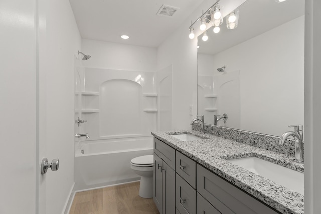 full bathroom with  shower combination, toilet, hardwood / wood-style floors, and vanity