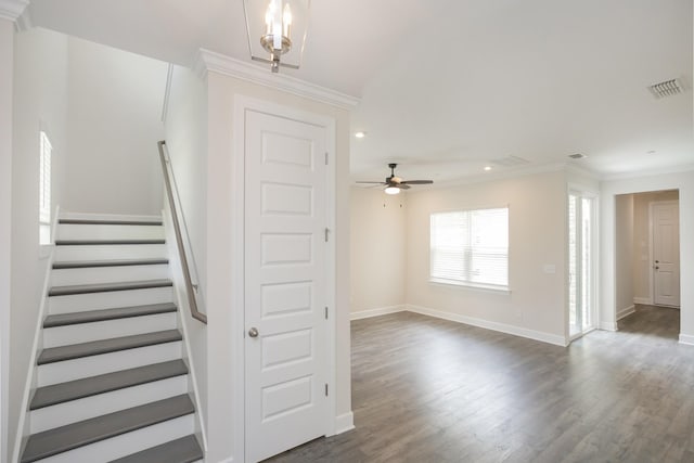 stairs featuring ceiling fan, ornamental molding, and hardwood / wood-style floors