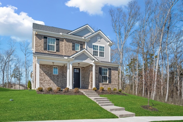 craftsman-style home with a front lawn and brick siding