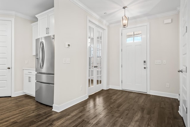 entrance foyer featuring dark wood-style floors, ornamental molding, and baseboards