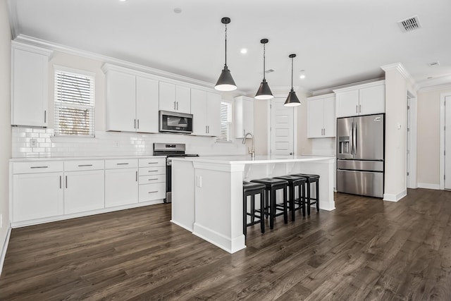 kitchen featuring stainless steel appliances, white cabinetry, a kitchen island with sink, and crown molding